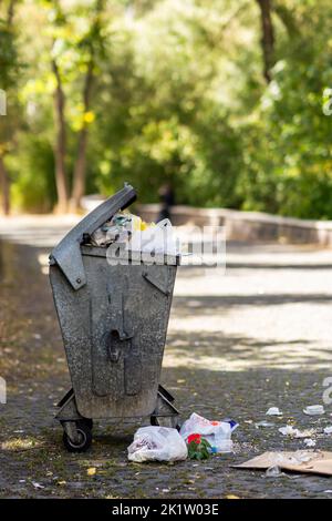 A public garbage container overflowed on the street. Environmental awareness concept. High quality photo Stock Photo