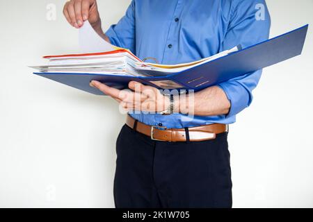 A businessman holding a blue paper holder and pointing to something in it Stock Photo