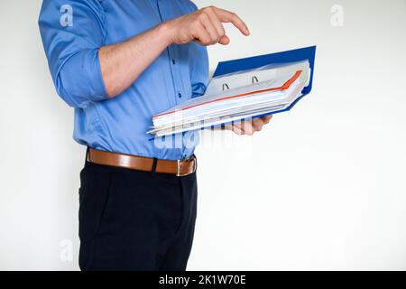 A businessman holding a blue paper holder and pointing to something in it Stock Photo