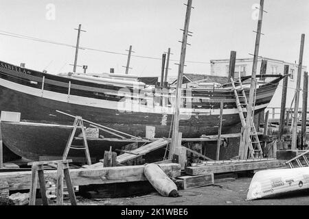 The Isabella a vintage wooden ship in drydock in Gloucester Harbor, Massachusetts. The image was captured on analog black and white film. Stock Photo