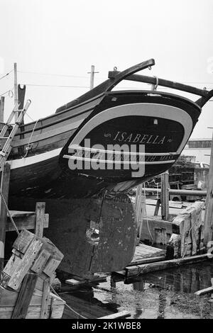 The Isabella a vintage wooden ship in drydock in Gloucester Harbor, Massachusetts. The image was captured on analog black and white film. Stock Photo