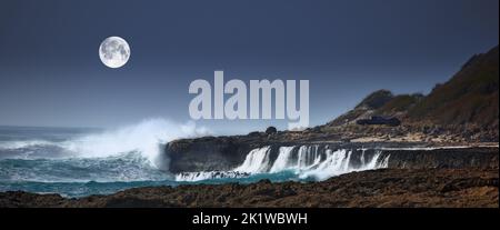 The moon over coast and big waves. A photo of the moon over stormy ocean coast. Stock Photo