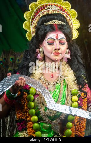 Concept Agomoni shoot with black haired Indian brunette woman face with perfect makeup and wearing jewelers with traditional dress like goddess Stock Photo