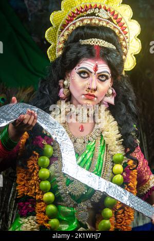 Concept Agomoni shoot with black haired Indian brunette woman face with perfect makeup and wearing jewelers with traditional dress like goddess Stock Photo