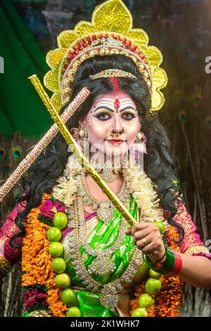 Concept Agomoni shoot with black haired Indian brunette woman face with perfect makeup and wearing jewelers with traditional dress like goddess Stock Photo