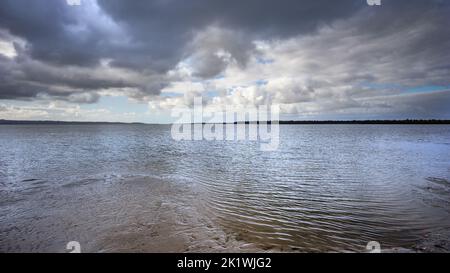 Dramatic storm clouds brewing over the sea and beach at Poona Beach, Queensland. Panorama looking across the Great Sandy Strait, along the Fraser Coas Stock Photo