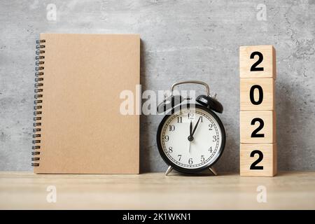 2022 Happy New Year with blank notebook, black retro alarm clock and wooden number. countdown, Resolution, Goals, Plan, Action and Mission Concept Stock Photo