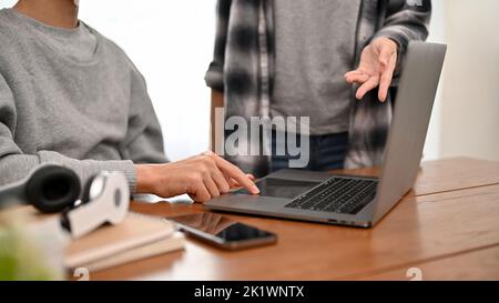 A professional male programmer or engineer working and discussing with his colleague in the office. cropped shot Stock Photo