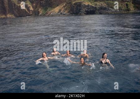 six young women enjoying a quick dip in the bay off Camara de Lobos in Madeira Stock Photo