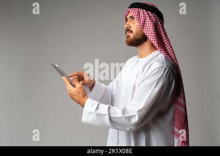 Arab businessman using digital tablet on gray background Stock Photo