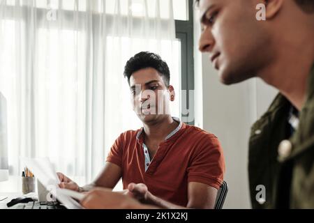 UI designer showing website wireframe to software developer Stock Photo