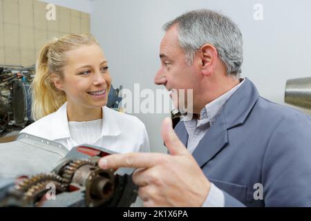 aero engineer and apprentice working in hangar Stock Photo