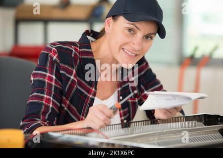 female worker installing new induction hob Stock Photo