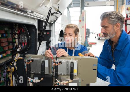 mechanics working on the electronics of a bus Stock Photo