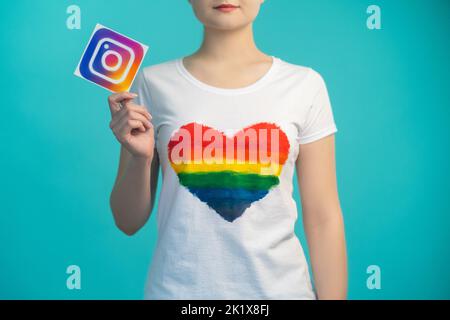 Kharkiv, Ukraine - November 27, 2020: Instagram icon. Social media. Mobile application. Online community. Woman in heart like t-shirt hand holding app Stock Photo