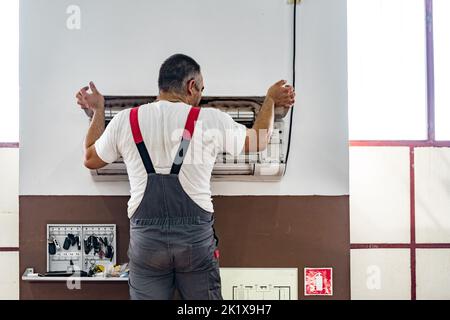 Repairman checking and repairing air conditioner indoors Stock Photo