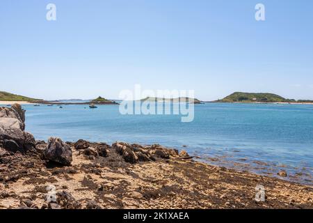 Looking across Tresco Flats from the quay at New Grimsby, Tresco, towards Bryher and Samson, with St. Mary's in the far distance: Isles of Scilly, UK Stock Photo