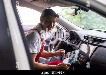car service, repair, technology, maintenance and people concept - mechanic man with tablet pc computer making system diagnostic at workshop Stock Photo