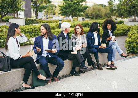 Multiethnic business women doing lunch break outdoor from office building - Focus on left man face Stock Photo