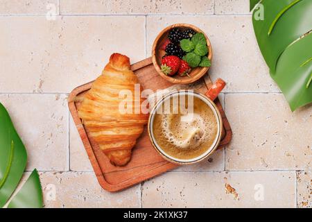 Coffee cup, berries and croissant. Flat lay