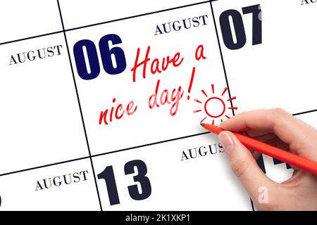 6th day of August. The hand writing the text Have a nice day and drawing the sun on the calendar date August 6. Save the date. Summer month, day of th Stock Photo