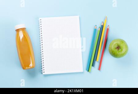 Blank notepad and colorful pencils. Flat lay over blue background with copy space Stock Photo