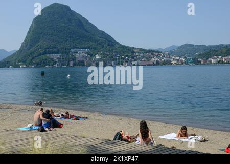 Lugano, Switzerland - 19June 2022: people sunbathing on the beach at Lugano on Switzerland Stock Photo