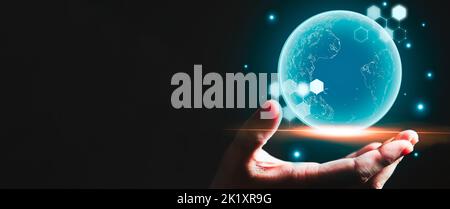 Businessman hand holding blue glowing earth hologram with copy space black background. Business and technology concept. Modern tech and metaverse them Stock Photo