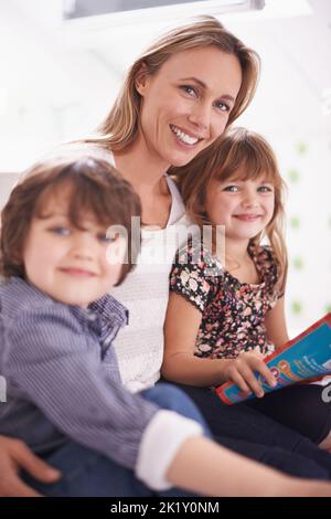 We love story itme. a mother reading with her children at home. Stock Photo