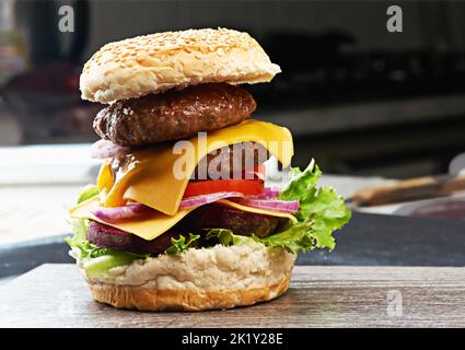 Tre hamburger con un tritare carne, verdure e formaggio su una piastra di  ferro, vista dall'alto Foto stock - Alamy