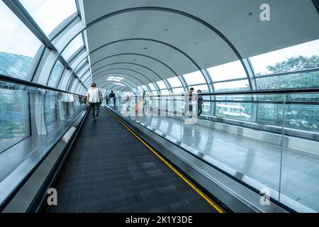 Passengers transiting between terminals on travelator at Changi International Airport, Singapore Stock Photo