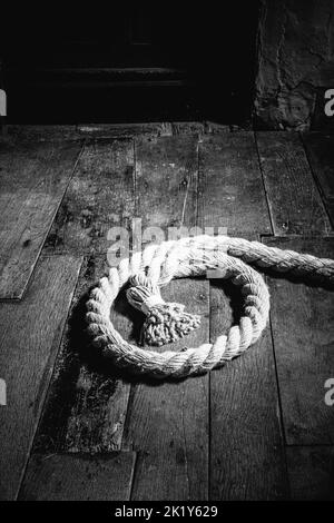 A coil of rope on oak floorboards in a medieval moated manor house. Stock Photo