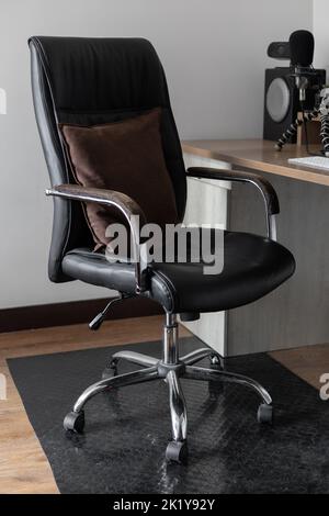 office swivel chair on wheels, ergonomic and black leather, in an office interior, workplace, furniture Stock Photo