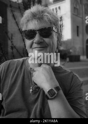 A dramatic grayscale shot of a man wearing sunglasses Stock Photo