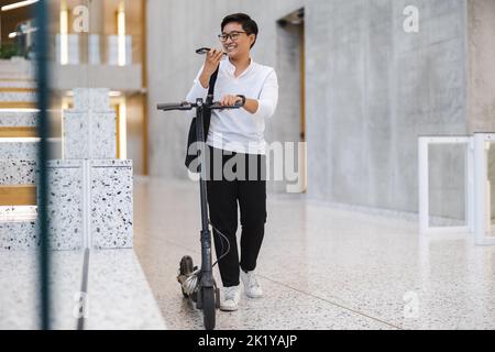 Young man with an electric scooter Stock Photo