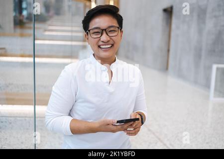Smiling young man using mobile phone Stock Photo