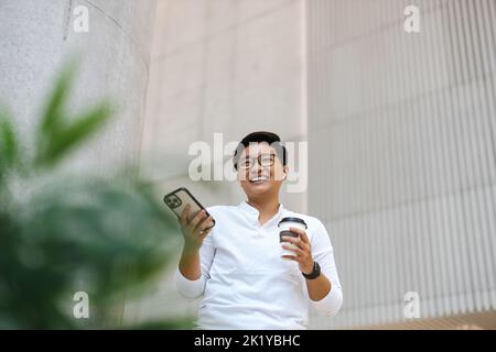 Smiling young man using mobile phone Stock Photo