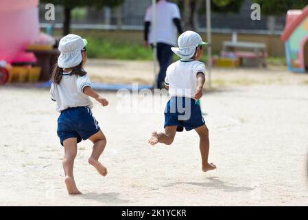 Children running on the ground during sports day at a Japanese kindergarten pre-school Stock Photo