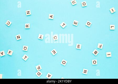 Random letters on a blue background. Scattered English alphabet.Abstract minimalist background Stock Photo