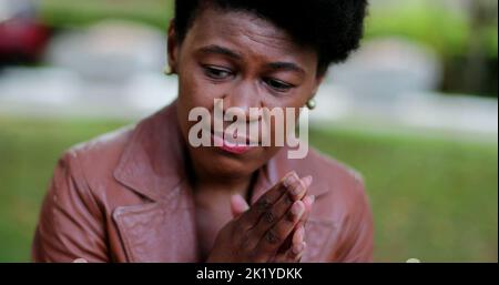 Troubled African woman praying to God seeking help and support Stock Photo