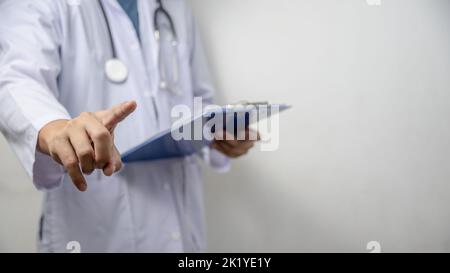 Doctor pressing button on virtual screen on background copy space for text. Stock Photo