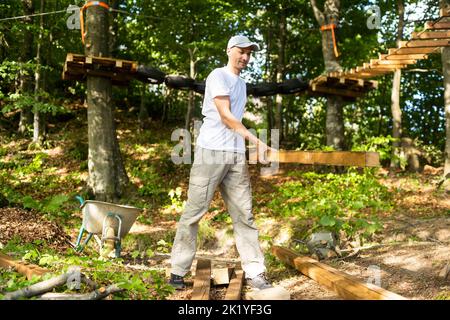 Young manual worker standing at stack with thin wooden boards during his work at furniture factory Stock Photo
