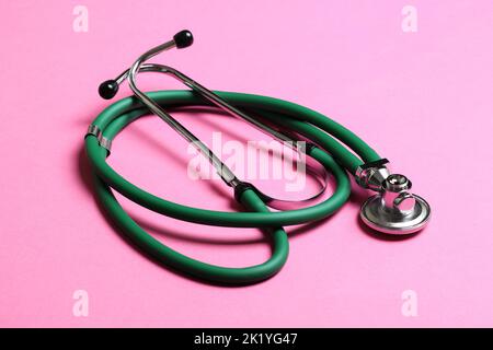 Top view of green stethoscope on colorful background. Medical diagnosis tool concept. Stock Photo