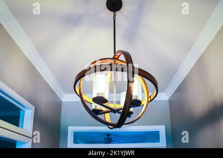 A suspended hanging orb light fixture in a front entrance of an Acadian style home or house Stock Photo