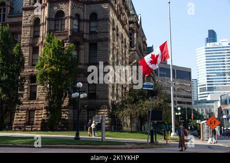 A Canadian flag at half mast or half staff in downtown Toronto at the Old City Hall on Queen Street; seen after the death of HM Queen Elizabeth II. Stock Photo