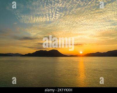 Sun Setting Low Sun sits low over ocean off coast Stock Photo - Alamy