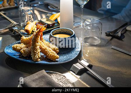 Seafood dishes on the oriental cousin table with crispy tempura shrimps and other appetizers such as spring rolls Stock Photo