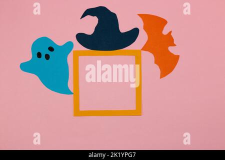 orange frame on pink background with copy space, eye frame ghost, bat and witch hat, flat lay, paper craft, creative halloween design Stock Photo
