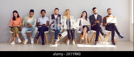 People reading or using devices while waiting for business appointment or job interview Stock Photo
