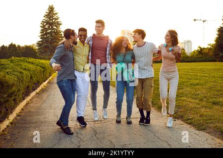 Joyful, happy and carefree young best friends have fun walking together in city park. Stock Photo